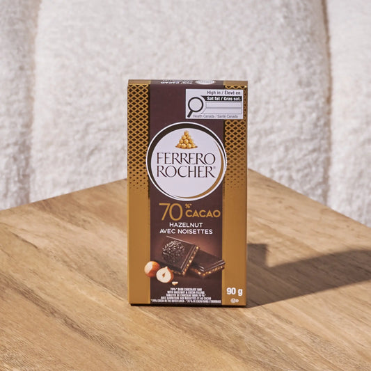 Ferrero Rocher 70% hazelnut chocolate on a wooden surface with a textured white background