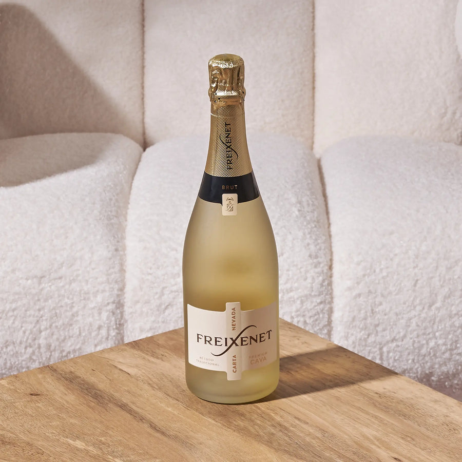 Freixenet Carta Nevada Brut Cava bottle on a wooden table with a soft, neutral background
