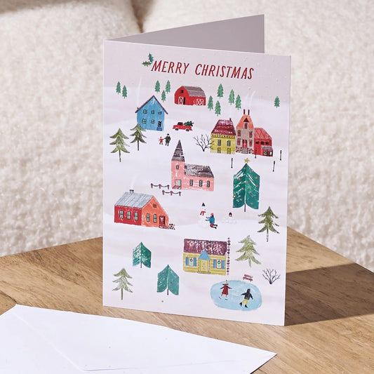 Merry Christmas greeting card on top of a table with a white envelope