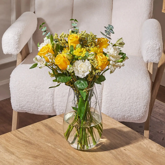 yellow rose bouquet with white carnations and greenery floral arrangement in vase