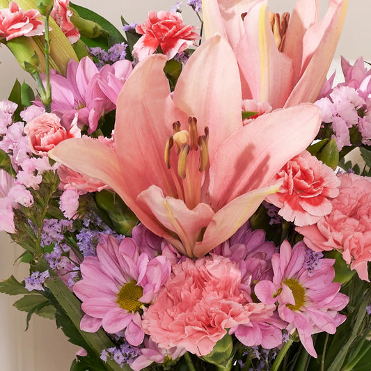 close up shot of Bouquet of pink and purple flowers with lilies and carnations.